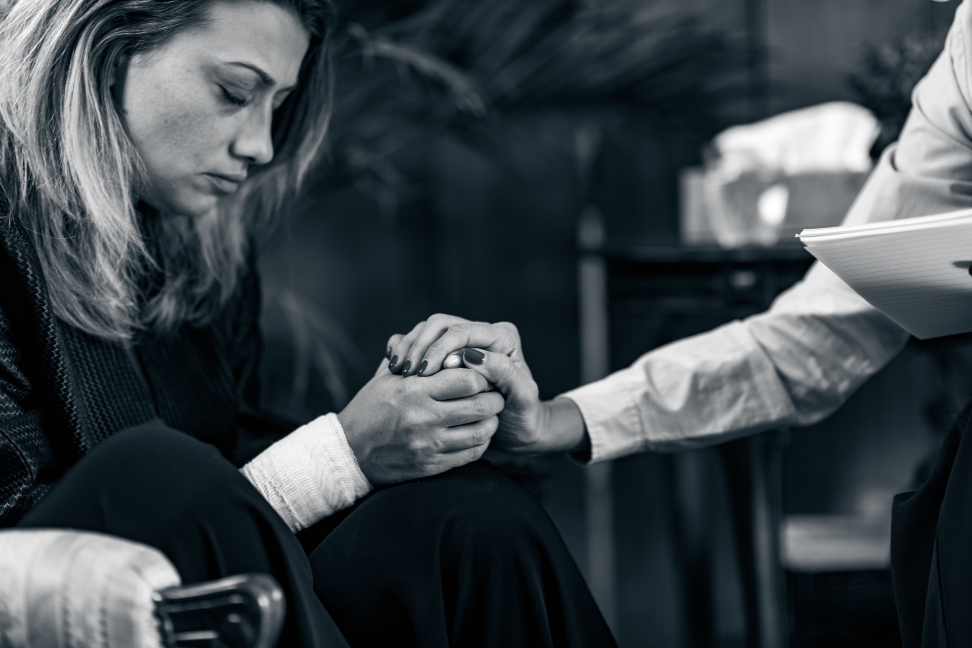 Profissional segurando a mão de familiar em luto durante orientação sobre pensão de sobrevivência e pensão de viuvez em Sintra, Cascais, Oeiras, Amadora e Loures.